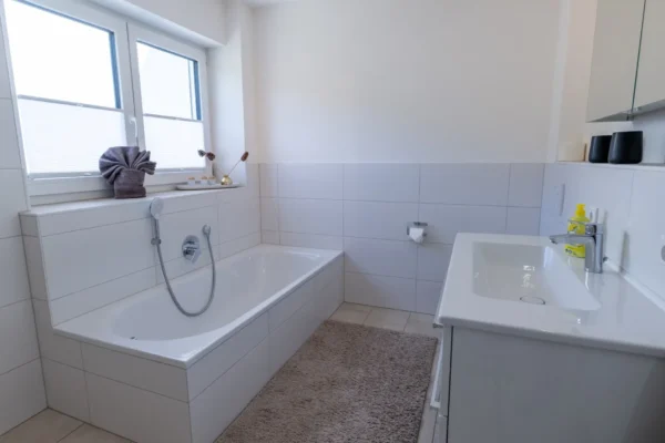 Modernes weisses Badezimmer im Ferienhaus Aura mit Badewanne, Handbrause und Waschtisch