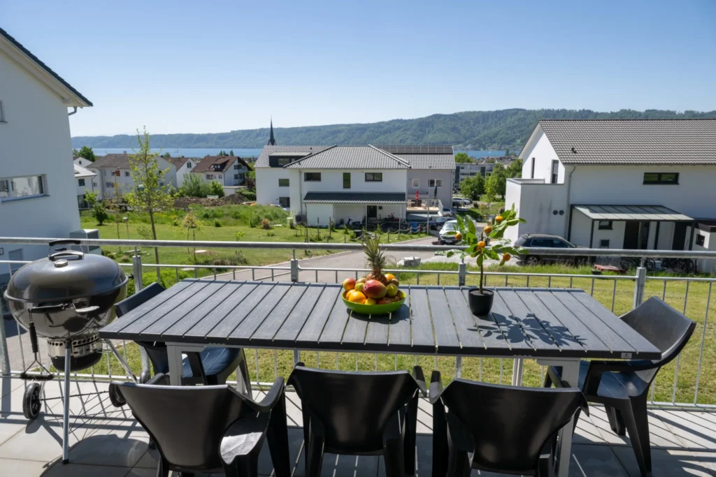 ferienhaus-aura-balkon-grill-esstisch-seeblick Grosser Balkon im Ferienhaus Aura mit Grillplatz, Esstisch, Obstschale und Seeblick auf den Bodensee